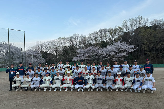 桜をバックに集合写真をとる選手と首脳陣